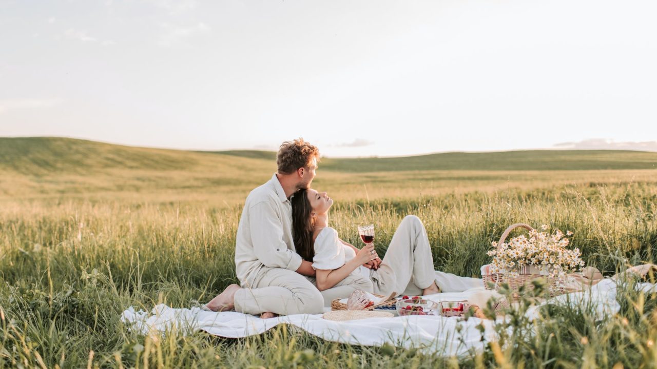 man and woman sitting on grass field